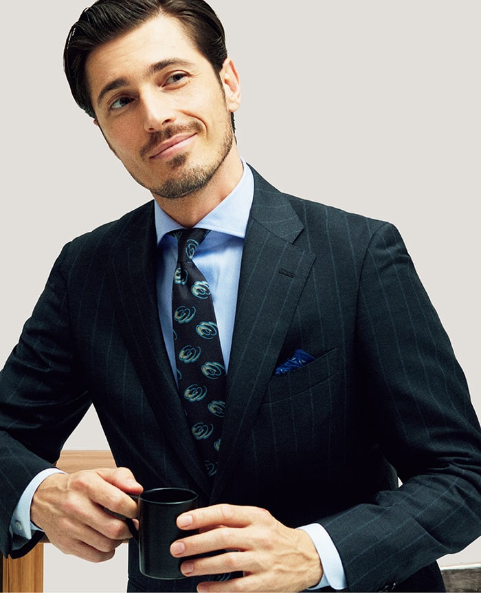 色柄のコントラストが低めなワイドピッチのストライプ生地は、従来のストライプのようにかっちりしすぎず着こなしやすい注目株。チャコールにサックスのストライプを凝らした、ドラゴ社のSUPER130’sウールを用いたサンタルチアモデルもそのひとつです。色柄を拾ったブルー系の合わせが洒脱。