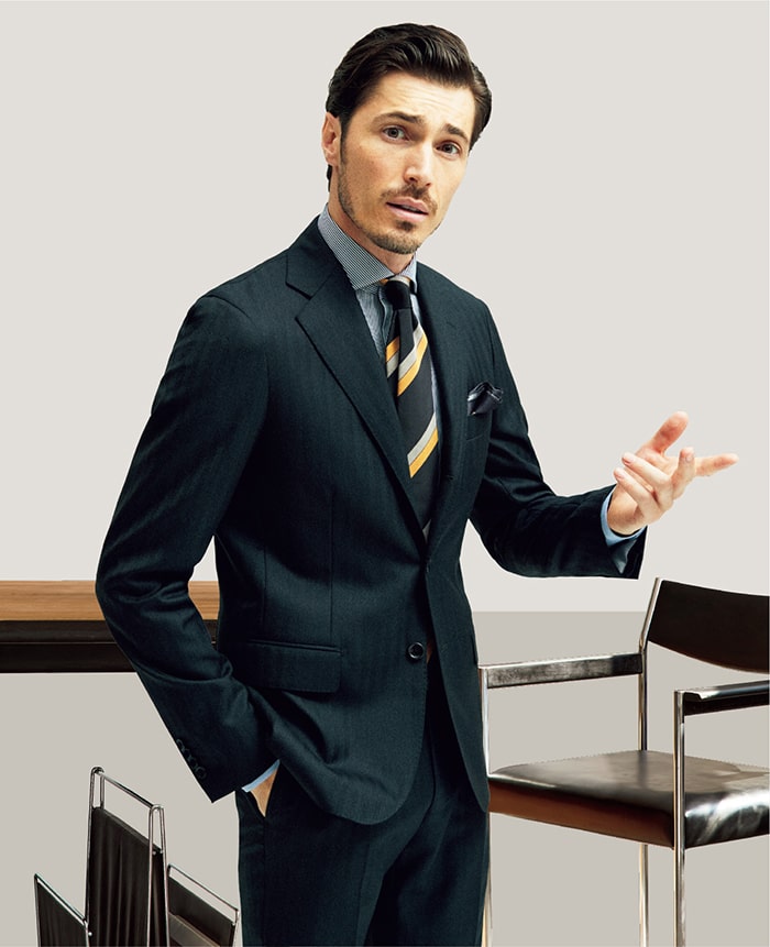 あえて太い繊維のウールを用い、カノニコ社の誇る高度な技術で織り上げることで、しっかりとしつつもしなやかなこれまでにない風合いに仕上げた新作生地「21 マイクロン」使用。仕立て映えする生地であり、チャコールのヘリンボーン織りと相まって、都会的で凛々しい佇まいです。