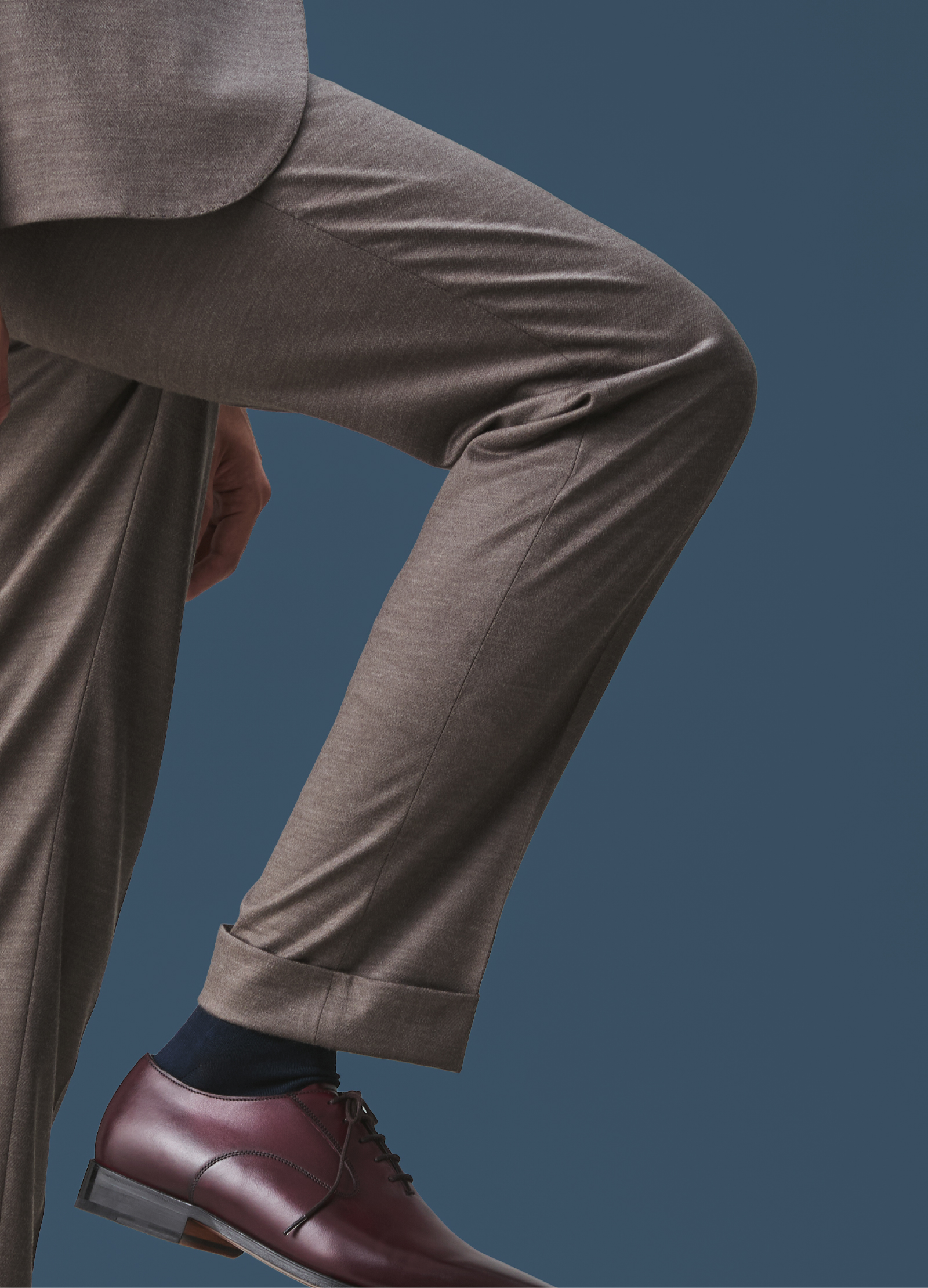 脚の動きに伸縮するグレージュのパンツ