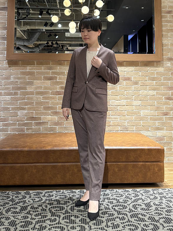 優しいベージュが特徴のノーカラースーツ